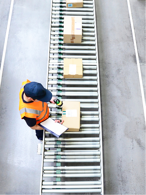 物流倉庫のコンベアラインで出荷確認を行う作業者